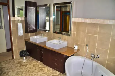 a bathroom with two sinks and a bath tub at Ambonnay Terrace Guest House in Pretoria