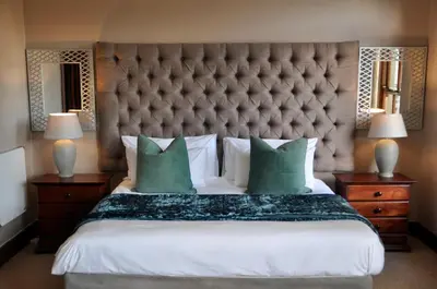 a bedroom with a large bed with green pillows at Ambonnay Terrace Guest House in Pretoria