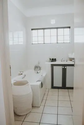 a white bathroom with a tub and a sink at @Kruger in White River