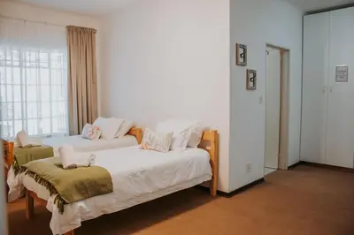 a bedroom with two beds and a window at @Kruger in White River