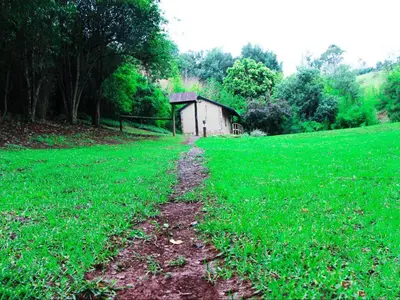 a dirt road in a field with a small building at Incwala Lodge in Waterval Boven