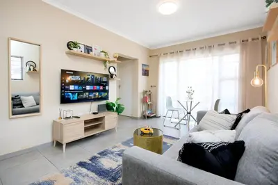 a living room with a couch and a tv at Michelle's Hospitality Hub in Midrand