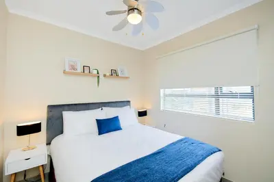 a bedroom with a bed and a ceiling fan at Michelle's Hospitality Hub in Midrand
