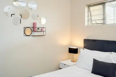 a bedroom with a bed and a mirror on the wall at Michelle's Hospitality Hub in Midrand