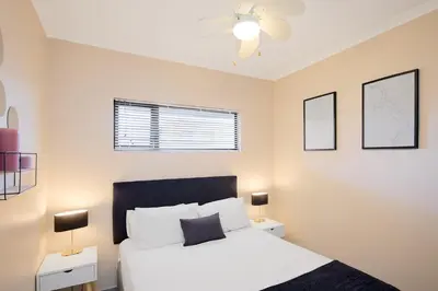 a bedroom with a white bed and two night stands at Michelle's Hospitality Hub in Midrand