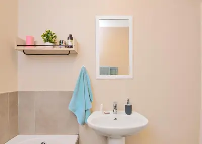 a white bathroom with a sink and a mirror at Michelle's Hospitality Hub in Midrand