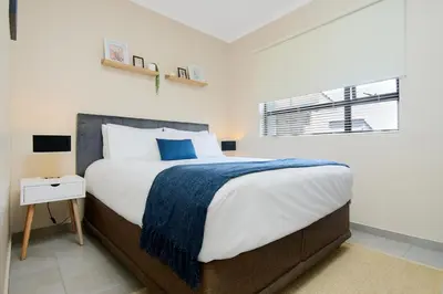 a bedroom with a large bed with a blue blanket at Michelle's Hospitality Hub in Midrand