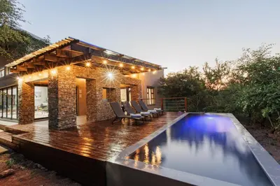 a backyard with a swimming pool and a house at Chawal stays @ Leguan in Marloth Park