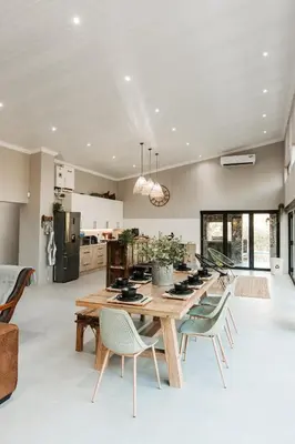 a kitchen and dining room with a wooden table and chairs at Chawal stays @ Leguan in Marloth Park