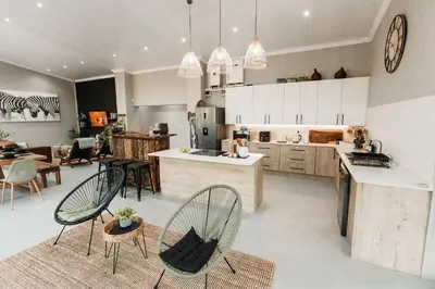 a large kitchen with two chairs and a table at Chawal stays @ Leguan in Marloth Park