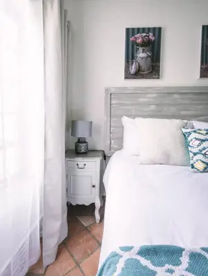 a bedroom with a bed and a table with a lamp at LilyRose Bed & Breakfast in Pretoria