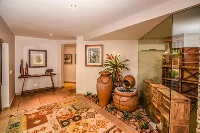 a living room with a large vase on the floor at Impangele River Lodge in Hectorspruit