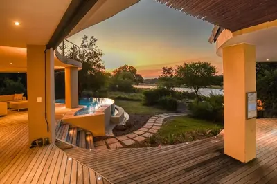 a house with a deck with a swimming pool at Impangele River Lodge in Hectorspruit