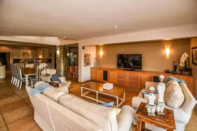 a living room with white couches and a table at Impangele River Lodge in Hectorspruit
