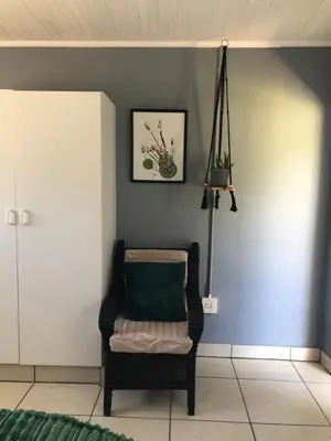a chair in a room with a blue wall at Kieron's Cottage in Lydenburg