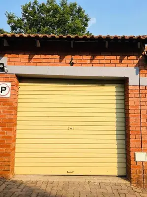 a yellow garage door on a brick building at Wanderlust 2-bedroom Apartment in Centurion