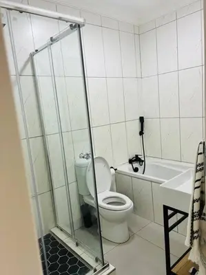 a bathroom with a toilet and a sink and a shower at Wanderlust 2-bedroom Apartment in Centurion
