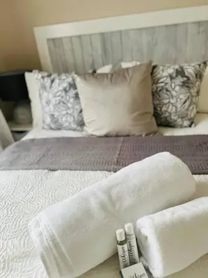 a bed with towels and pillows on top of it at Wanderlust 2-bedroom Apartment in Centurion