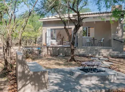 a house with a patio and a table in the yard at Wild Honey Studio in Marloth Park