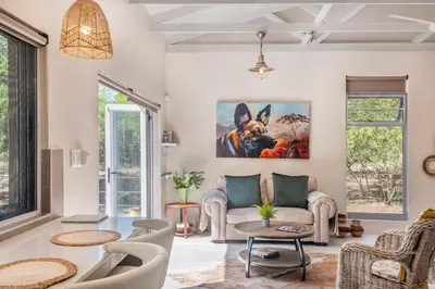 a living room with a couch and a painting of a dog at Wild Honey Studio in Marloth Park