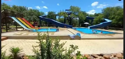 a large swimming pool with a slide in a park at Wild Honey Studio in Marloth Park