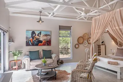 a living room with a couch and a table at Wild Honey Studio in Marloth Park