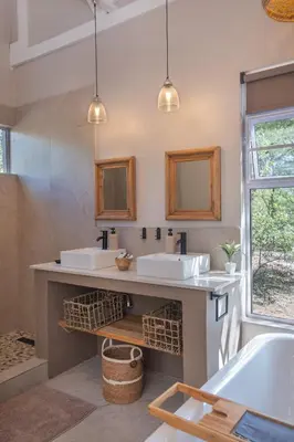a bathroom with two sinks and a tub at Wild Honey Studio in Marloth Park