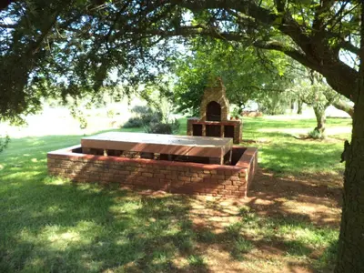 a brick bench in a park under a tree at Gateway Guesthouse in Benoni