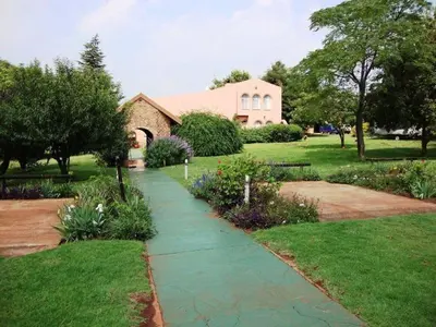 a garden with a walkway in front of a house at Gateway Guesthouse in Benoni
