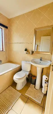 a bathroom with a toilet and a sink at A Warm 3 bed Townhouse in a secure complex in Witbank