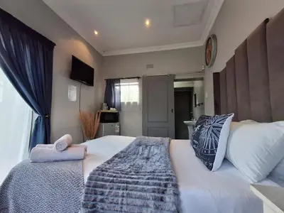 a bedroom with a large white bed and a window at OR Tambo Stay Unit 2 in Boksburg
