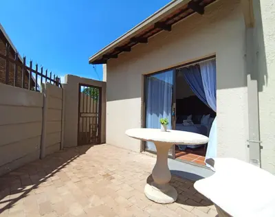 a patio with a white table in front of a house at OR Tambo Stay Unit 2 in Boksburg