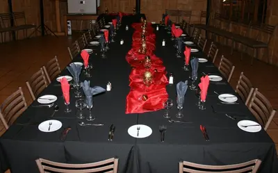 a long black table with red napkins and glasses at Pietersburg Lodge in Polokwane