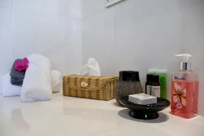 a bathroom counter with towels and toiletries on it at Rawlingsons Country House in Dullstroom
