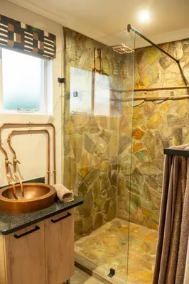 a bathroom with a sink and a shower at Buffelshuis Safari Camp in Golders Green