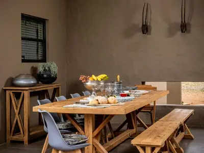a wooden table with a bowl of fruit on it at Buffelshuis Safari Camp in Golders Green