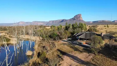 an aerial view of a house with a mountain in the background at Buffelshuis Safari Camp in Golders Green