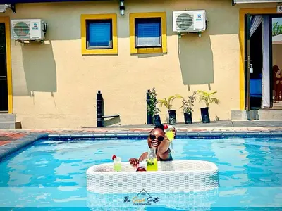 a child in a swimming pool with a drink at The Curve Suite Guest House in Nkowakowa