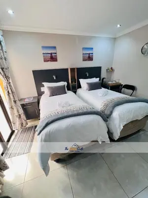 a bedroom with two beds in a room at The Curve Suite Guest House in Nkowakowa