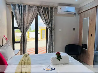 a bedroom with a large bed and a window at The Curve Suite Guest House in Nkowakowa