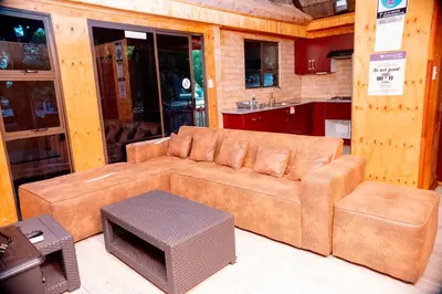 a living room with a brown couch and a table at Falcon Lodge Bela Bela in Bela-Bela