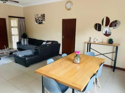 a living room with a table and a couch at Bela Waterfront Villa in Bela-Bela