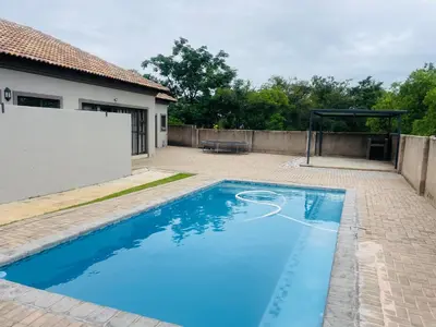 a swimming pool in a backyard with a gazebo at Bela Waterfront Villa in Bela-Bela