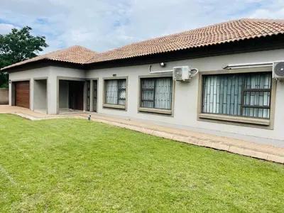 a house with a green lawn in front of it at Bela Waterfront Villa in Bela-Bela