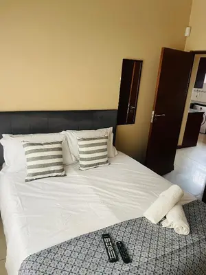 a bed with two remote controls on top of it at Bela Waterfront Villa in Bela-Bela