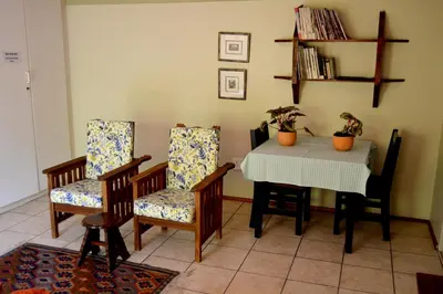 a dining room with a table and two chairs at Petal Faire Cottage in Pretoria
