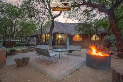 a patio with a table and a fire pit at Nag-Apie Vakansiehuis in Marloth Park