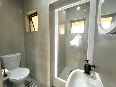 a bathroom with a toilet and a sink and a shower at OR Tambo Stay Unit 1 in Boksburg