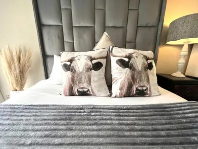 a bed with two cow pillows on it at OR Tambo Stay Unit 1 in Boksburg