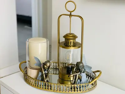 a gold candle holder with candles and birds on it at Luxury Holiday Homes - The Blyde in Pretoria